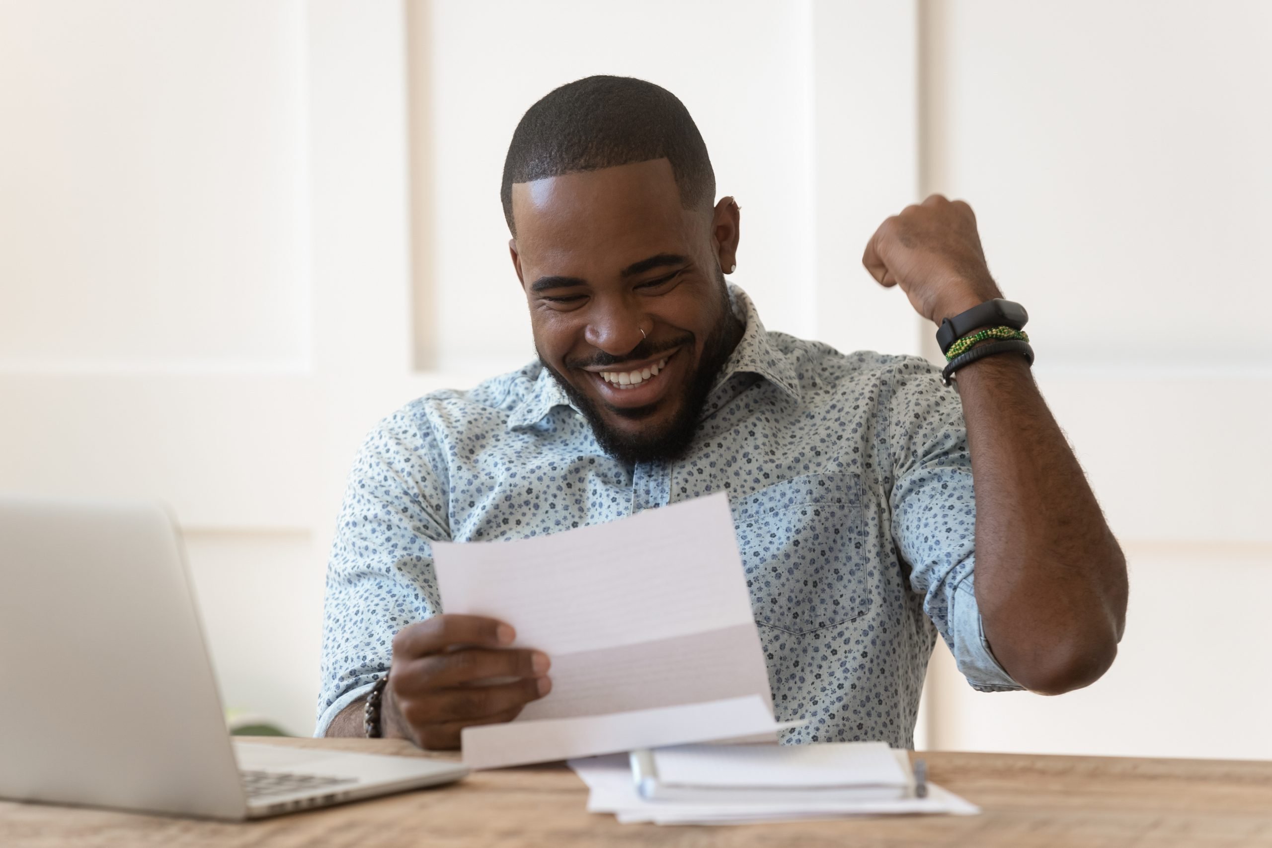 Happy african american guy received banking loan approval.